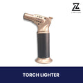 Gold and black refillable butane torch lighter with standing base.